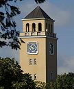 17_21509  Der Turm vom Rathaus in Hamburg Bergedorf ragt zwischen den Bumen empor - das Ziffernblatt der Turmuhr liegt auf blauem Grund mit goldener Zeiteinteilung; die Fassade vom Rathaus ist in einem zarten Ockergelb gehalten. www.hamburg-fotograf.com