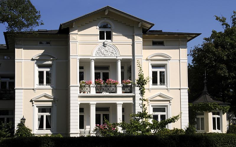 Fotografie Stadtvilla im Villenviertel von Hamburg Bergedorf - Architektur in der Hansesadt. Grnderzeitvilla mit Sulen und Stuckdekor im Bergedorfer Villenviertel; Ende des 19.  Jahrhunderts wurde begonnen, das sogenannte Villenviertel zu bebauen - wohlhabende Hamburger und Bergedorfer Brger lieen dort ihre reprsentativen Wohnhuser errichten. Es entstanden Stadthuser, die die unterschiedlichen Stile der Architektur ausdrckten - neben der Bauform der Grnderzeit wurde auch der Jugendstil architektonisch umgesetzt oder Wohnhuser in der Architektur der neuen Sachlichkeit gebaut.