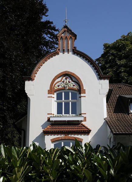 Bilder Jugendstilarchitektur Hamburg Bergedorf  Im Backsteindekor ber dem Fenster der Stadtvilla ist ein farbiges Jugendstildekor mit Blten und geschwungenen Linien angebracht. Dieses Stadthaus gehrt zum sogenannten Villenviertel in Hamburg Bergedorf - wohlhabende Hamburger und Bergedorfer Brger lieen dort ihre reprsentativen Wohnhuser errichten. Es entstanden Stadthuser, die die unterschiedlichen Stile der Architektur ausdrckten - neben der Bauform der Grnderzeit wurde auch der Jugendstil architektonisch umgesetzt oder Wohnhuser in der Architektur der neuen Sachlichkeit gebaut.