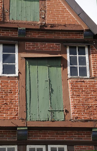 Fachwerkhaus - Speichertr Historisches Fachwerkgebude in der Bergedorfer Einkaufsstrasse Sachsentor. Das Fachwerk- haus wurde 1700 errichtet; die Farbe blttert von der Speichertr ab, die von zwei alten Trscharnieren / Langbndern gehalten wird.