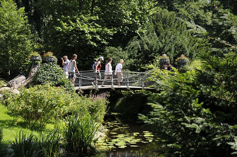 Bergedorfer Schloss - Brcke ber den Schlossgraben - Touristen im Schlosspark  17_21556Der Wassergraben vom Bergedorfer Schloss wird mit dem Wasser der Bille gespeist. Bergedorf Besucher gehen ber die historische Brcke ber den Schlossgraben in den Schlosspark. Ein Fotograf fotografiert die eisernen Blumenkbel, die an den Brckenenden als Dekoration stehen. www.hamburg-fotograf.com