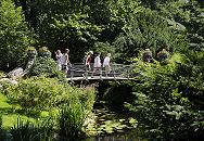 17_21556 Der Wassergraben vom Bergedorfer Schloss wird mit dem Wasser der Bille gespeist. Bergedorf Besucher gehen ber die historische Brcke ber den Schlossgraben in den Schlosspark. Ein Fotograf fotografiert die eisernen Blumenkbel, die an den Brckenenden als Dekoration stehen. www.hamburg-fotograf.com