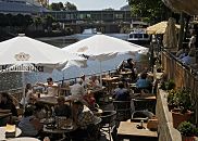 17_21565 Blick ber den Bergedorfer Hafen - ein Fahrgastschiff der Bergedorfer Schifffahrtslinie liegt am Kais vom Serrahn. Auf der Aussenterrasse eines Bistros am Hafen sitzen die Gste in der Sonne oder Sonnenschirmen. Im Hintergrund ist unter der Brcke die Zufahrt zum Schleusengraben zu erkennen. www.hamburg-fotograf.com