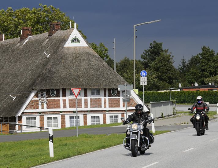 Zwei Motorrder fahren auf der Deichstrasse an der Elbe entlang - die Biker geniessen die kurvenreiche Strecke an der Elbe. Die Bergedorfer Vier- und Marschlande sind ein beliebtes Ausflugsziel fr die Hamburger - ein reetgedecktes Fachwerkhaus steht hinter Deichanlage die es vor dem Hochwasser der Elbe schtzen soll Bilder vom Hamburger Ausflugsgebiet Bergedorf - Motorrder am Elbdeich, Reetdach