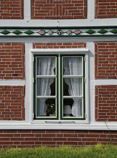 Fotografie Fenster + Schnitzerei Fachwerkhaus  Holzfenster in einem Fachwerkhaus; die Gardinen sind mit Spitzen versehen. Der Balken ber dem Fenster ist mit farbig abgesetzten Schnitzereien versehen