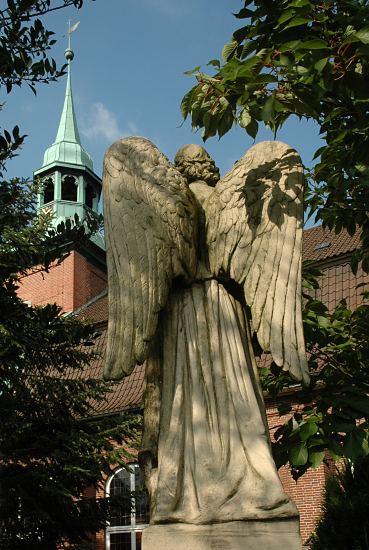 Bilder Hamburger Kirchen, St. Pankratius Engel Skulptur mit Flgeln auf dem Friedhof in Hamburg Ochsenwerder. Im Hintergrund die St. Pankratiuskirche; die Kirche St. Pankratius  fand schon 1254 ihre erste urkundliche Erwhnung; der jetzige Bau stammt aus dem Jahre 1674, der Kirchturm aus dem 18. Jh.