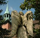 17_21642 Engel Skulptur mit Flügeln auf dem Friedhof in Hamburg Ochsenwerder. Im Hintergrund die St. Pankratiuskirche; die Kirche St. Pankratius  fand schon 1254 ihre erste urkundliche Erwähnung; der jetzige Bau stammt aus dem Jahre 1674, der Kirchturm aus dem 18. Jh. ©www.hamburg-fotograf.com