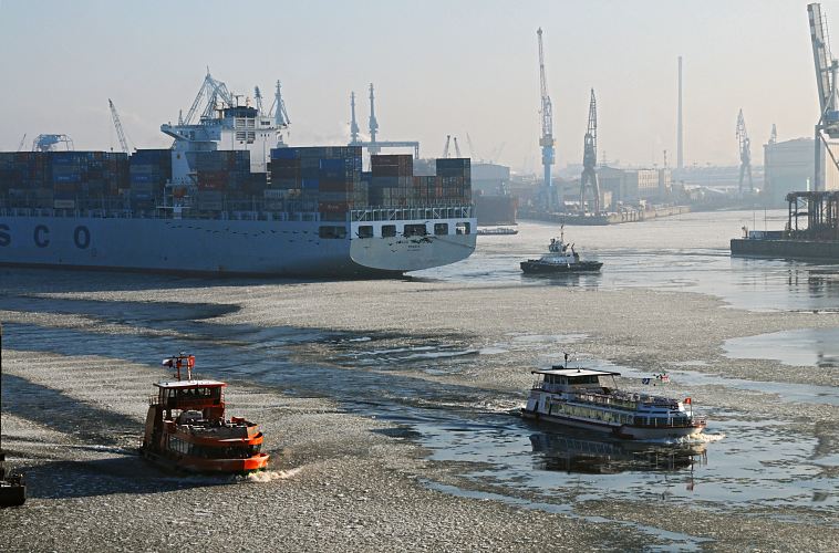 001_22730 Die Elbe ist mit Treibeis bedeckt; ein Containerschiff wird von einem Schlepper rckwrts in das Hafenbecken vom Tollerort Terminal geschleppt. Eine Hafenfhre bahnt sich ihren Weg durch das Eis auf der Elbe und steuert den Anleger "Dockland" an, whrend ein weiteres Fahrgastschiff mit Touristen an Bord auf seiner Hafenrundfahrt ist.. www.hamburg-fotograf.com