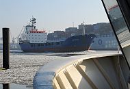 004_22733 Der niederlndische Containerfeeder Klostertal fhrt durch den Eisgang auf der Elbe flussabwrts - das Schiff spiegelt sich in der Scheibe einer Hafenfhre. Hinter dem Frachtschiff luft ein hoch beladener Containerfrachter in den Hamburger Hafen ein. 