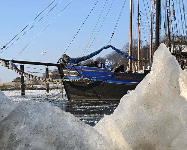 Hamburger Motive vom Winter in Hamburg, historisches Segelschiff im Museumshafen. Blick durch die Eisschollen im Museumshafen auf den Bugsprit eines historischen Segelschiffs. www.hamburg-fotograf.com