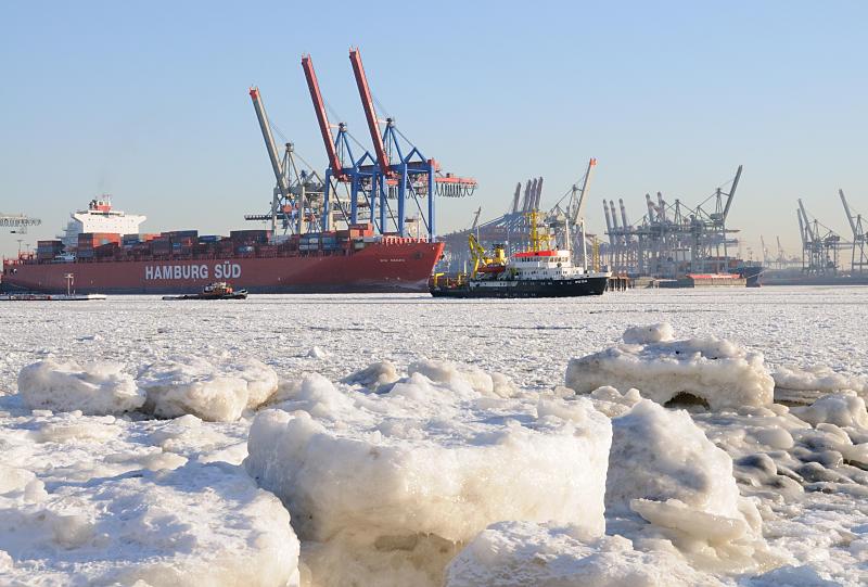 Hamburger Wintermotive - Eisschollen am Elbufer - Treibeis auf der Elbe. 01_5795 Das Elbufer ist mit dicken Eisschollen bedeckt - im suchen sich einige Schiffe ihren Weg. Am Container Terminal Burchardkai liegt ein rotes Containerschiff der Reederei Hamburg Sd. www.hamburg- fotograf.com