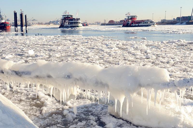 05_5688 Frost und Eis in Hamburg - ein Schiffstau am Anleger velgnne ist mit dickem Eis und Eiszapfen bedeckt, die in der Wintersonne glnzen. Zwei Hafenfhren fahren durch das dichte Treibeis auf der Elbe. Fotos vom Hamburger Winter - vereistes Schiffstau und Hafenfhren auf der Elbe.