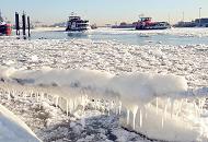 05_5688 Frost und Eis in Hamburg - ein Schiffstau am Anleger velgnne ist mit dickem Eis und Eiszapfen bedeckt, die in der Wintersonne glnzen. Zwei Hafenfhren fahren durch das dichte Treibeis auf der Elbe. Fotos vom Hamburger Winter - vereistes Schiffstau und Hafenfhren auf der Elbe.