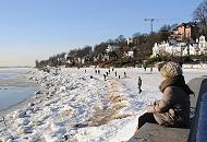 07_5730 Die Wintersonne scheint in Hamburg - Spaziergnger genieen das sonnige Wetter beim Spaziergang an der Elbe. Der Elbstrand ist mit Eis bedeckt, Kinder spielen am Ufer des Flusses. Am Hang stehen die Wohnhuser von Hamburg Oevelgoenne. Hamburg Motive von den Jahreszeiten - Hamburger Winter, Spaziergnger am Elbufer. 