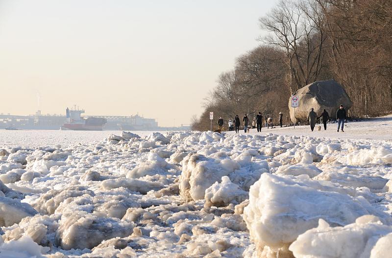 08_5797 Spaziergnger genieen das sonnige Hamburgwetter am Elbufer. Am Strand liegt der Findling ALTER SCHWEDE, der 1999 bei Baggerarbeiten in der Elbe gefunden wurde. Der Stein hat ein geschtztes Alter von 1,8 Milliarden Jahren und ein Gewicht von 217 t; er wurde vor ca. 400 000 Jahren whrend der Elster-Eiszeit aus dem Raum Schweden mit den Gletschern hierher gebracht. Hamburg-Bilder von den Jahreszeiten - Winter an der Elbe, Elbufer mit Eisschollen. 