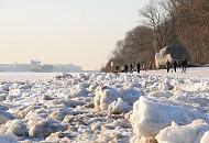 08_5797 Spaziergnger genieen das sonnige Hamburgwetter am Elbufer. Am Strand liegt der Findling ALTER SCHWEDE, der 1999 bei Baggerarbeiten in der Elbe gefunden wurde. Der Stein hat ein geschtztes Alter von 1,8 Milliarden Jahren und ein Gewicht von 217 t; er wurde vor ca. 400 000 Jahren whrend der Elster-Eiszeit aus dem Raum Schweden mit den Gletschern hierher gebracht. Hamburg-Bilder von den Jahreszeiten - Winter an der Elbe, Elbufer mit Eisschollen. 