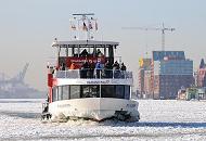 11_5639 Die Hafenfhren verbinden die einezelnen Stadtteile diesseits und jenseits der Elbe - die Fhre  WILHELMSBURG  kommt von Hamburg Finkenwerder und fhrt ber Altona zu den St. Pauli Landungsbrcken. Touristen stehen auf dem Vorderdeck und fotografieren die Schiffe auf der vereisten Elbe.  Fotos aus der Hansestadt Hamburg im Winter -  Elbfhre WILHELMSBURG fhrt durchs Treibeis.