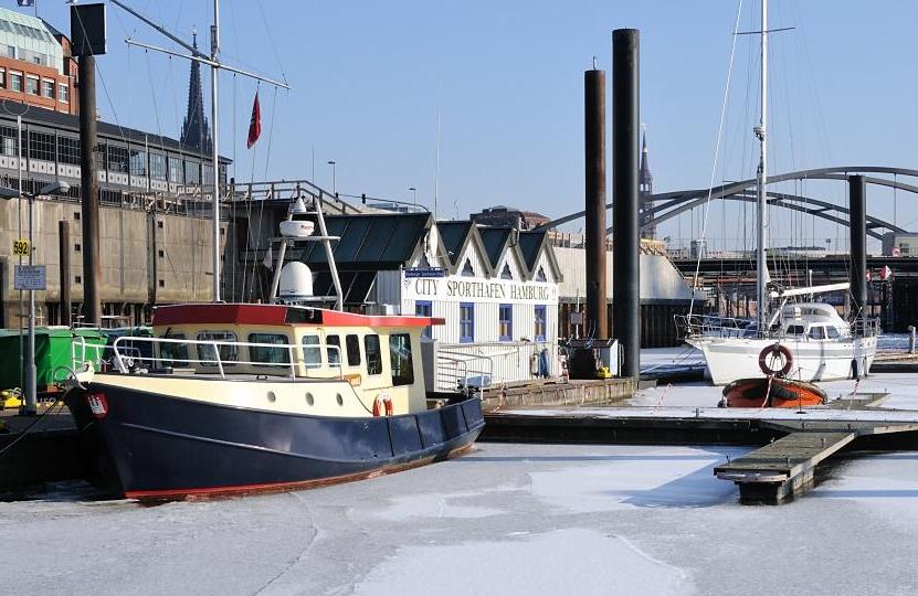 1685 Einzelne Sportboote liegen im zugefrorenen City Sporthafen Hamburg - die Boote sind von der Eisdecke eingeschlossen. Im Hintergrund der Kirchturm der St. Katharinenkirche und die Oberbaumbrcke.