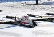 1690 Ein Sportboot liegt im winterlichen Sportboothafen der Hamburger City am Baumwall am Steg. Das kleine Schiff ist von der Eisdecke, die das Hafenbecken bedeckt, eingeschlossen.