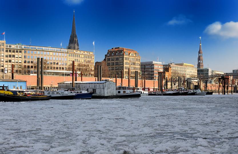 1701 Das Wasser des Hamburger Binnenhafens ist mit einer dicken Eisdecke bedeckt - Schiffe liegen am Anleger. Im Hintergrund Kontor- und Geschftshuser sowie die Kirchtrme der St. Nikolai- und Katharinenkirche.