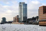 1760 Elbufer in der Altonaer Altstadt - moderne Hamburger Brogebude am Rande der Elbe im Bereich des ehemaligen Holzhafens von Hamburg Altona. Eisschollen bedecken den Fluss; im Hintergrund Huser an der Grossen Elbstrasse. 