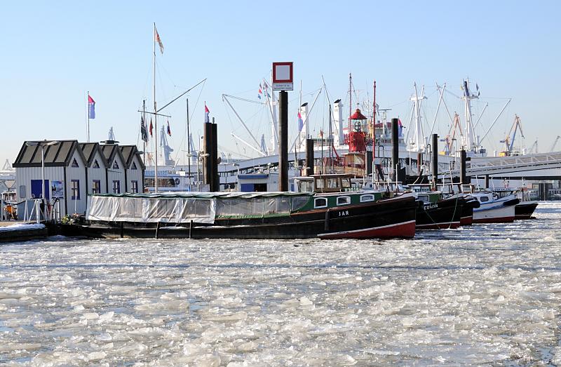 17_5629 Barkassen der Hafenrundfahrt liegen vertut im Eis des Niederhafens. Das dichte Treibeis der Elbe machen die Touristiktouren durch den Hafen fast unmglich. Links die Pontonhuschen des City-Sportboothafens. Hamburger Winterbilder -Barkassen der Hafenrundfahrt im Eis des Niederhafens am Baumwall.