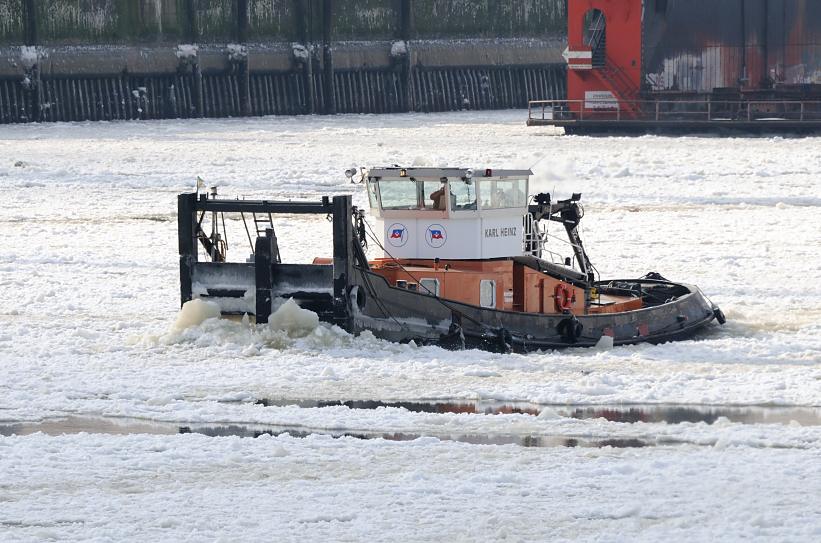 1828 Ein Schubschiff fhrt als Eisbrecher durch das dichte Treibeis im Hamburger Hafen - dicht trmen sich die Eisschollen vor dem Bug des Arbeitsschiffs; die Elbe ist dicht mit Eis bedeckt.