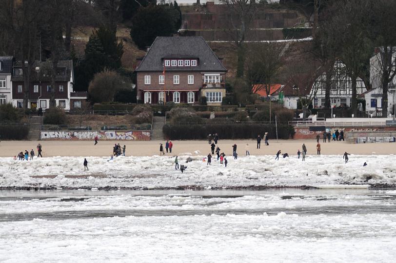 1891 Spaziergang im Winter an der Elbe - Eisschollen liegen auf dem Elbstrand; Kinder turnen auf den Eisbergen. Spaziergngerer gehen am winterlichen Elbstrand oder blicken auf die Elbe; Wohnhuser von Hamburg Oevelgnne. 