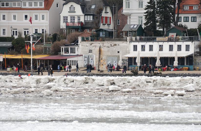 1891 Winterspaziergang an der Elbe - die SpaziergngerInnen machen an der Strandperle eine Pause und blicken auf die vereiste Elbe. Es ist Niedrigwasser und das Eis hat sich am Elbufer hoch abgelagert. Im Hintergrund Wohnhuser von Hamburg Oevelgnne.