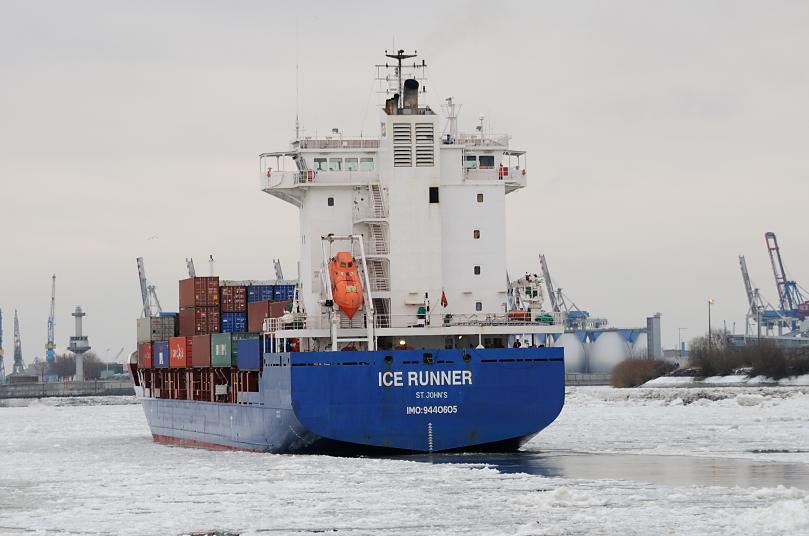 1903 Der Container Feeder ICE RUNNER luft auf der vereisten Elbe in den Hamburger Hafen ein. Das Frachtschiff hat eine Lnge von 129 m und eine Breite von 20m und kann 700 TEU Standard-Container transportieren. Im Hintergrund die Faultrme des Hamburger Klrwerks am Khlbrand. 