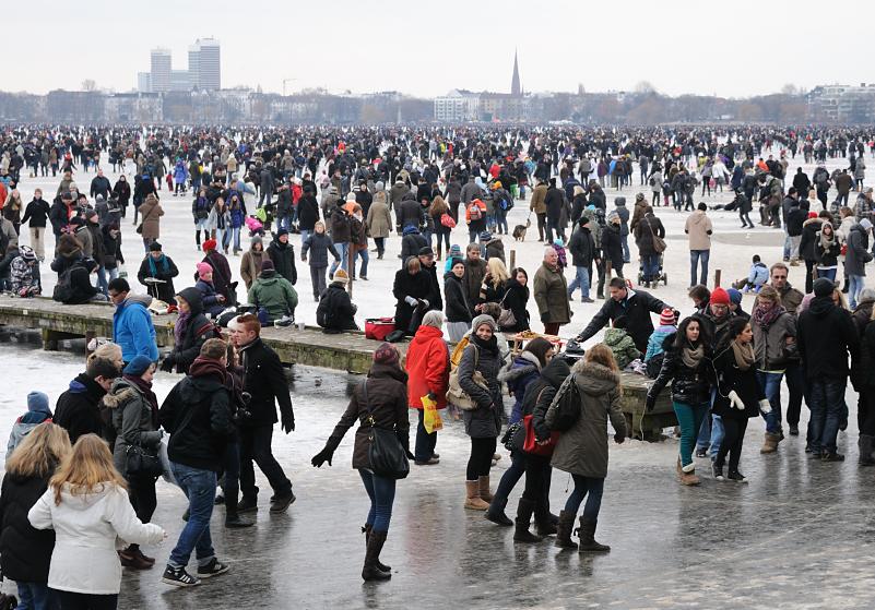 2048 Die Menschen strmen auf die zugefrorene Auenalster - andere sitzen auf einem Holzsteg, ziehen ihre Schlittschuhe an oder beobachten das bunte Treiben.