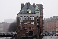 2067 Blick auf das Wasserschlsschen in der Hamburger Speicherstadt an einem grauen Wintertag. Das Fleet ist mit Eisschollen bedeckt, das historische Gebude spiegelt sich im Wasser. 