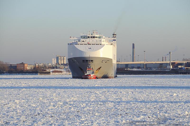 20_5847 Der Autotransporter HEGH AMERICA wird von dem Schlepper ZP CONDON aus dem Hansahafen in die Fahrrinne der Elbe gezogen. Das Wasser im Hamburger Hafen ist bei den langanhaltenden winterlichen Temperaturen mit dichtem Treibeis bedeckt. Hamburger Hafenbilder im Winter -Autotransporter mit Schlepper im Eis.