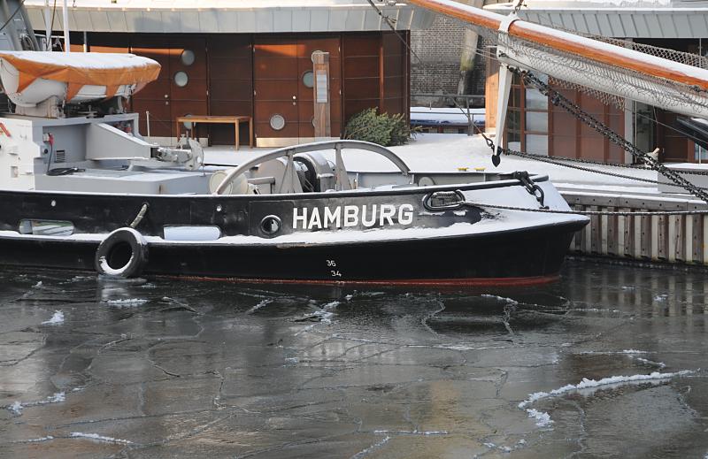 23_4879 Das Wasser im Sandtorhafen, dem neuen Hamburger Traditionsschiffhafen, ist mit Eis bedeckt - am Ponton liegt der historische Schlepper FAIRPLAY VIII. Hamburger Hafenmotive, der Traditionsschiffhafen am Sandtorhafen im Winter.
