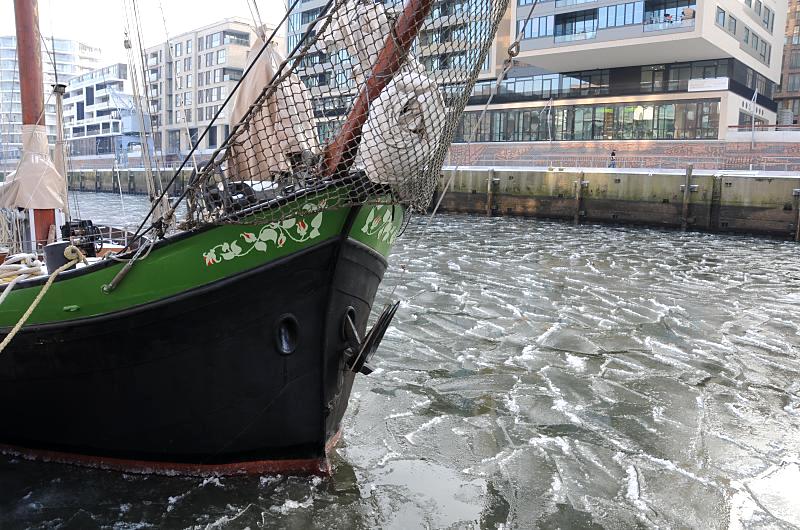 24_4887 Der Sandtorhafen wurde neben dem Museumshafen Oevelgoenne zu einem weiteren Hamburger Traditions- schiffhafen eingerichtet. Ein historisches Segelschiff liegt im Eis des Hafenbeckens; am gegenber liegenden Kaiserkai die moderne Architektur der Hamburger Hafencity.  Hamburger Hafenmotive im Winter - im Sandtorhafen berwintert ein historisches Segelschiff.