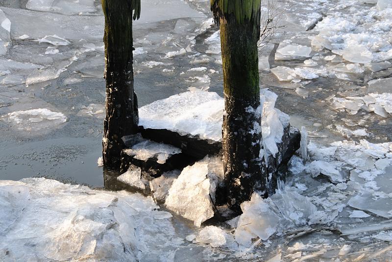 27_4842 An einem alten Holzdalben, die zum Anlegen von Schuten und Frachtschiffen gedienen, haben sich Eisschollen aufgestaut. Durch das schwere Treibeis ist die Schifffahrt auf der Elbe und den Hamburger Kanälen teilweise eingestellt worden. Winter-Impressionen von Hamburg - Eisschollen in der Hamburger Speicherstadt.
