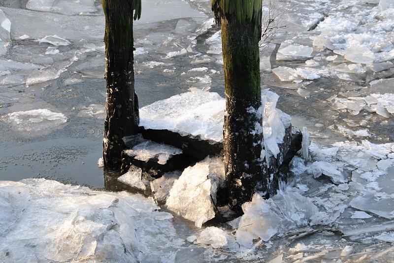 27_4842 An einem alten Holzdalben, die zum Anlegen von Schuten und Frachtschiffen gedienen, haben sich Eisschollen aufgestaut. Durch das schwere Treibeis ist die Schifffahrt auf der Elbe und den Hamburger Kanlen teilweise eingestellt worden. Winter-Impressionen von Hamburg - Eisschollen in der Hamburger Speicherstadt.