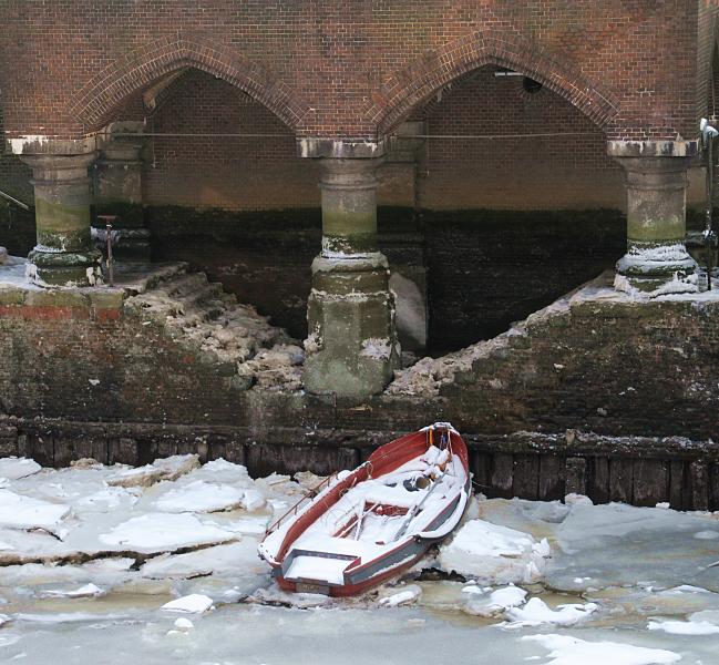 28_5271 Ein Ruderboot liegt am Anleger bei der St. Annenbrcke im Eis des Hollndischen Brook Fleet. Es ist Niedrigwasser - die Treppen die zum Anleger fhren sind mit Eis bedeckt.  Hamburger Winterimpressionen - Ruderboot im Eis.