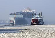 2988 Der Containerfrachter COSCO GUANGZHOU luft in den Hamburger Hafen ein - ein Schlepper dirigiert den Containerriesen im Fahrwasser der Elbe. Ein Raddampfer der Groen Hafenrundfahrt fhrt durch das Elbeis auf seiner Tour durch den vereisten Hafen Hamburgs. 