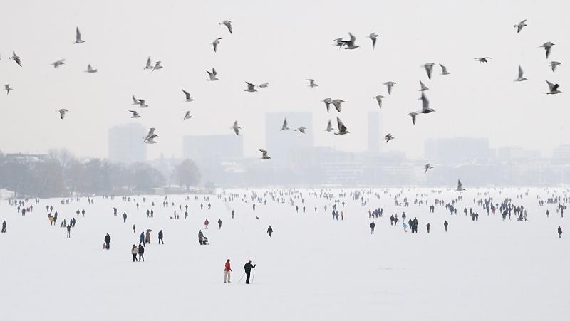 Eisiger Winter in der Hansestadt - Hamburger und Hamburgerinnen auf dem Eis der Alster.