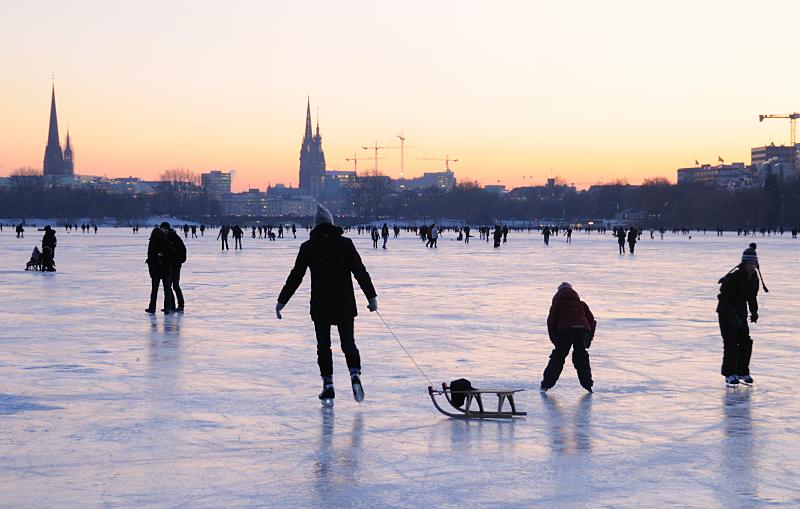 58_5942 Die zugefrorene Alster bedeutet fr die Hamburger ein Volksfest. Bis in den spten Abend wird auf dem Alstereis Schlittschuh gelaufen oder geschlendert. Fotos vom winterlichen Hamburg - Schlitten fahren und Schlittschuhlaufen auf der abendlichen Alster.