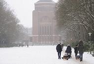 66_5083 Familien gehen im Schnee des Hamburger Stadtparks spazieren - Vter ziehen ihre Sprsslinge auf dem Schlitten oder tragen sie Huckepack, eine Mutter schiebt ihren Kinderwagen durch den Schnee auf dem Weg zum Planetarium. Der Schriftzug steht in goldfarbenen Buchstaben an der Fasse des 78m hohen Gebudes. Fotos vom Winter in der Hansestadt Hamburg - Familienspaziergang im winterlichen Stadtpark.