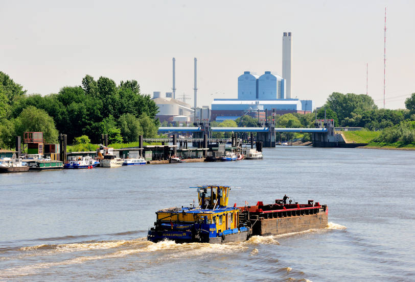 01134_2700 Schubschiff mit Schute in Fahrt auf der Norderelbe - lks. die Anleger / Pontons bei Entenwerder. In der Bildmitte das Sperrwerk Billwerder Bucht.; dahinter die Industriearchitektur vom  Heiskraftwerk Tiefstack.