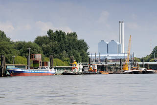 01135_6713 Arbeitsschiffe am Anleger Entenwerder, Hamburg Rothenburgsort / Norderelbe; am Ponton haben ein Binnenschiff und mehrere Schlepper festgemacht - ein Schwimmkran liegt zwischen mehreren Schuten. Dahinter die Tore vom Sperrwerk Billwerder Bucht und die hohen Gebude und Schornsteine vom Heizkraftwerk Tiefstack.