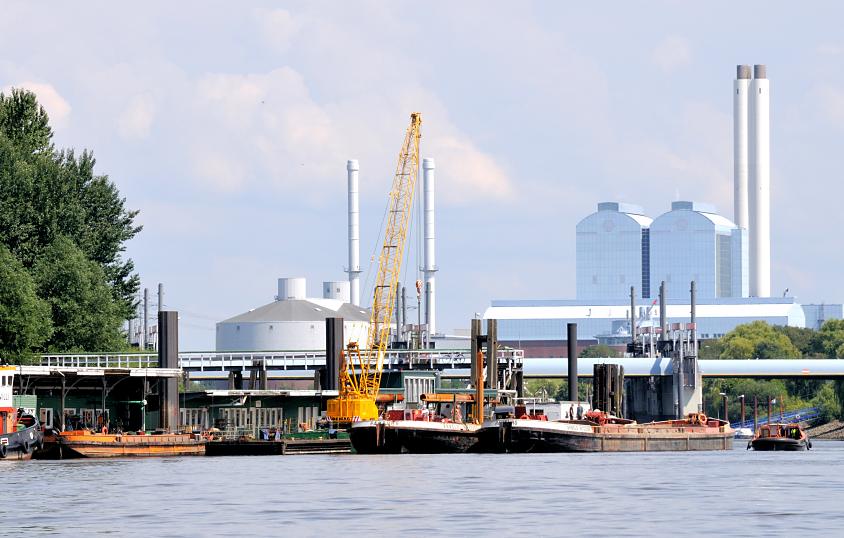01136_6713 Arbeitsschiffe am Anleger Entenwerder, Hamburg Rothenburgsort / Norderelbe; am Ponton haben ein Schwimmkran lund mehrere Schuten festgemacht. Dahinter die Tore vom Sperrwerk Billwerder Bucht und die hohen Gebäude und Schornsteine vom Heizkraftwerk Tiefstack.