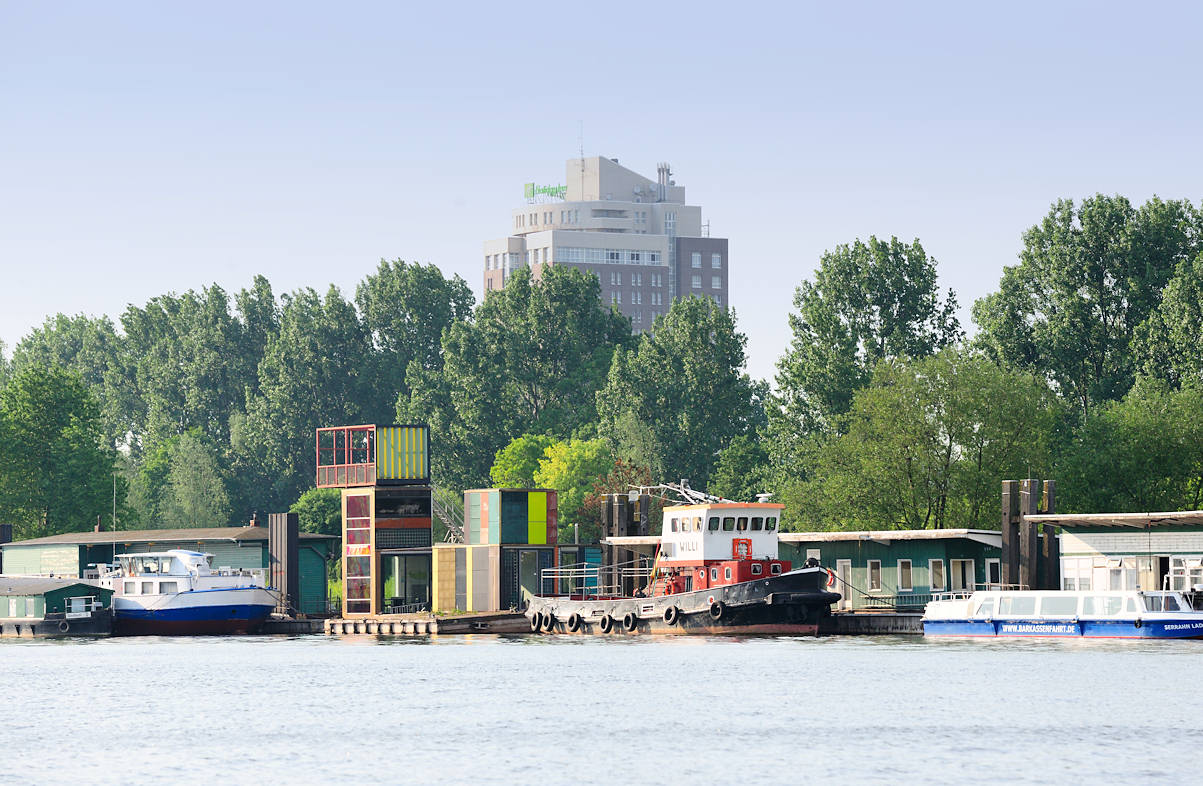 01138_2596 Alter Zollanleger / Zollstation Entenwerder, Hamburg Rothenburgsort - der Schlepper WILLI und das Fahrgastschiff SERRAHN LADY haben am Ponton festgemacht. Neben einfachen Holzhusern steht eine moderne Bro-Architektur mit Aussichtsturm. Im Hintergrund hinter den Bumen des Elbparks Entenwerder das Hotel HOLIDAY INN. 