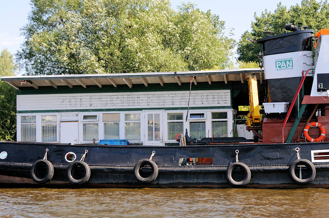 01145_5874 Alte Holzbaracke auf dem Ponton Entenwerder / Hamburg Rothenburgsort; die Umrisse der Aufschrift ZOLLSCHIFFSTATION der ehemaligen Zollstation Entenwerder ist noch zu erkennnen. Ein Arbeitsschiff, Schlepper hat festgemacht - Autoreifen dienen als Fender.