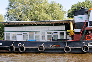 01145_5874 Alte Holzbaracke auf dem Ponton Entenwerder / Hamburg Rothenburgsort; die Umrisse der Aufschrift ZOLLSCHIFFSTATION der ehemaligen Zollstation Entenwerder ist noch zu erkennnen. Ein Arbeitsschiff, Schlepper hat festgemacht - Autoreifen dienen als Fender.