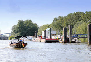 01155_8345 Ein historisches Tuckerboot kommt aus der Billwerder Bucht und passiert den Anleger in Entenwerder, Hamburg Rothenburgsort. Im Hintergrund die Norderelbbrcken. 