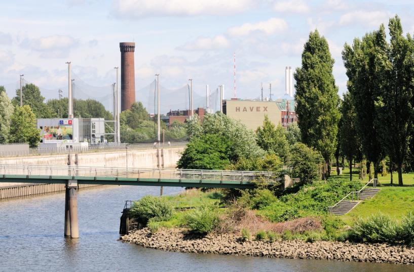 01192_5851 Blick von den Norderelbbrcken zum Haken in Hamburg Rothenburgsort. Rechts Bume und Rasenflche vom Elbpark Entenwerder und hinter der Fussgngerbrcke ber das ehemalige Hafenbecken die Netze der Golfanlage und der Wasserturm / Wasserspiel der Hamburger Wasserwerke.